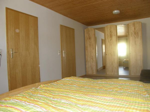 Schalfzimmer für 3 Personen mit einem 5-türingen Kleiderschrank. Die linke Tür führt zu einem WC mit Waschbecken und durch die rechte Tür gelangen Sie wieder in das Wohnzimmer. - Bild 12: Ostseeurlaub mit Hund - Wassergrundstück Piratennest Darß
