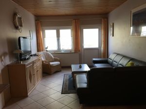 Der gemütliche Wohnbereich ist ausgestattet mit vielen Bildern, einer Couchgarnitur, einem Fernseher, Radio usw.. Die … integrierter Küche verfügt über einen Geschirrspüler, 4Platten-Ceranfeld mit Backofen, Kühlschrank mit Gefrierfach, Mikrowelle, Kaffemaschine, Toaster und alles was Sie zum Kochen benötigen. Sicherlich werden Sie so manche nette Stunde bei einer duftenden Tasse Kaffee oder Tee oder einem Glas Rotwein oder bei eimem Kartenspiel mit Ihren Kindern an unserem Esstisch verbringen. - Bild 8: Ostseeurlaub mit Hund - Wassergrundstück Piratennest Darß