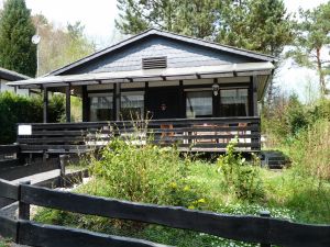 Das Ferienhaus mit Blick auf den Eingang und die Veranda mit gemütlicher Sitzecke. - Bild 1: Eifel-Ferienhaus Fliegenpilz - für Ihren Urlaub mit und ohne Hund