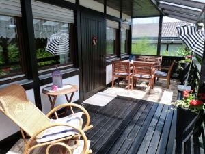 Die gemütliche Sitzecke und der Schaukelstuhl laden zum Relaxen und Verweilen ein. - Bild 3: Eifel-Ferienhaus Fliegenpilz - für Ihren Urlaub mit und ohne Hund