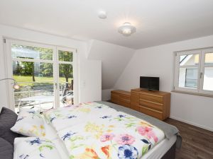 Schlafzimmer 2 im OG mit Boxspringbett - Fernseher und Balkon - Bild 12: exklusive Reetdach Villa nur 500 Meter bis zum Strand für 6+2 Personen