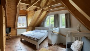 Das offene Schlafzimmer im Obergeschoss unseres Ferienhauses ist mit einem Doppelbett (Liegefläche 1,6 m) und mit einer Schlafcouch (Liegefläche 1,6 m) ausgestattet - Bild 13: Ferienhaus BUTEN gemütliche Doppelhaushälfte mit Terrasse und Garten