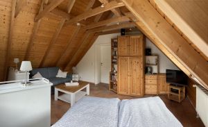 Im Dachgeschoss befindet sich ein Doppelbett sowie eine Schlafcouch mit Sitzgruppe. Hinten im Bild die Tür zum zweiten Schlafzimmer. - Bild 15: Ferienhaus BUTEN gemütliche Doppelhaushälfte mit Terrasse und Garten