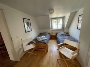 Das Schlafzimmer grenzt an den Wohn-/Schlafbereich im Dachstudio an. Die Einzelbetten können bei Bedarf einfach zusammen geschoben werden. An das Schlafzimmer ist ein separates WC angeschlossen. - Bild 16: Ferienhaus BUTEN gemütliche Doppelhaushälfte mit Terrasse und Garten