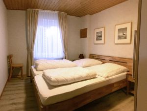 Schlafzimme mit Doppelbett Kleiderschrank und Nachtschränken - Bild 7: Ferienhaus Landkirchen Thomsen in ruhiger Lage