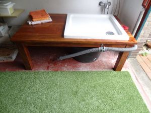 Im Bereich eines Abstellraumes (ehem. Garage) befindet sich die Warmwasser-Hundedusche. Ein Kunstrasen auf dem Boden verhindert, daß es evtl. nasse Füße für den Menschen gibt und er bietet sich zum Abtrocknen der geduschten Tiere an. - Bild 11: Hundefreundliche komfortable Vier-Sterne-FeWo mit Sauna an der Nordsee