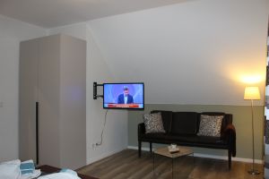 Schlafzimmer mit Doppelbett, Fernseher und Leseecke - Bild 19: Ferienhaus Kiek Över mit Sauna und Kamin in Prerow