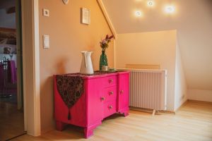 Schlafzimmer im OG Schlafzimmer 3 im Obergeschoß
Das Schlafzimmer ist mit einem 1,40 Meter Bett, Nachtschränckchen, Leselampen, einem Kleiderständer, Ventilator und einer kleinen Kommode ausgestattet. - Bild 14: Ferienhaus Hirtengarten Odenwald Tiere willkommen Hessen