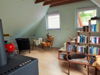 Wohnzimmer im OG Wohnzimmer im Obergeschoß
Das Wohnzimmer ist mit Kaminofen und Lese-Ecke eingerichtet.
Es ist einiges an Büchern, Spielen, DVD ´s und CD´s für Groß und Klein vorhanden.
Auch verfügt es über ein Schlafsofa auf dem zusätzlich jemand schlafen kann sowie einer Ottomane.
Natürlich gibt es hier auch eine Ecke für die vierbeinigen Gäste.
Auch hier ist ein Ventilator vorhanden. - Bild 19: Ferienhaus Hirtengarten Odenwald Tiere willkommen Hessen