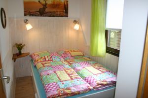 Hier grüßt Sie das "Hirschchen":
1 Doppelbett (1,40m x 2m) mit Bettschublade, 1 geräumiger Kleiderschrank, 1 Bücherregal und 1 Nachtkonsölchen. - Bild 15: Idyll. Ferienhaus EifelNest & uneinsehb. Sonnenterrasse mit Fernblick