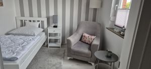 Gemütliches 2. Schlafzimmer mit Bett, Nachttisch, KLeiderschrank, Sessel und Tisch - Bild 12: Nordsee Ferienhaus Dornumersiel strandnah - Hund willkommen - WLAN