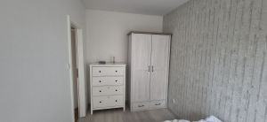 Schlafzimmer mit bequemen Bett, Nachttisch, Kleiderschrank und Kommode - Bild 10: Nordsee Ferienhaus Dornumersiel strandnah - Hund willkommen - WLAN