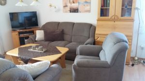 Wohnzimmer mit bequemer Couchgarnitur,
SAT-TV, Tisch, Vitrine und Sekretär - Bild 5: Ferienhaus "Kristina" an der ostfriesischen Nordseeküste - Hunde erlaubt