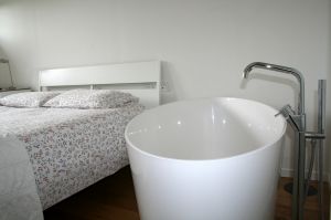 außergewöhnliches Schlafzimmer mit großer Badewanne - Bild 15: Ferienhaus Regina mit eingezäunten Garten und Seeblick