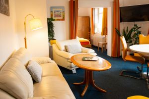 Sofalandschaft, TV und Essbereich - Bild 3: Ferienwohnung "Der Falkenhorst" Alleinlage im Wald