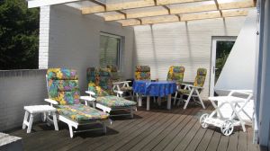 Die grosszügige Terrasse mit Holzboden lädt zum gemütlichen Verweilen ein. Die Hälfte ist überdacht und bietet von daher bei jedem Wetter ein Sitzvergnügen. Der Aussenkamin macht die Sache perfekt. - Bild 3: Nahe Grömitz Neustadt Pelzerhaken Rettin Ostsee Hunde willkommen