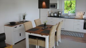 Das "Esszimmer" direkt an der offenen Küche. Mit Meerblick. Oder Sie setzen sich direkt auf die überdachte Terrasse. Mit Super-Meerblick.; -) Morgens, Mittags, Abends, hier ist es immer schön. Geniessen Sie das tolle Ambiente des Hauses und des Grundstücks. - Bild 5: Hundefreundliches Ferienhaus Meersicht Lübecker Bucht bei Grömitz