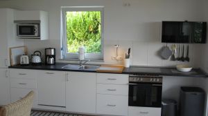 Die offene neue Küche ist voll ausgestattet. Geschirrspüler, Herd mit Ofen, Mikrowelle, Kühl- und Gefrierschrank, Kaffeemaschine, Toaster, Wasserkocher und was man eben alles so braucht. - Bild 4: Hundefreundliches Ferienhaus Meersicht Lübecker Bucht bei Grömitz
