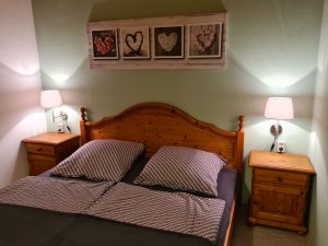 Schlafzimmer mit Doppelbett, zweitürigem Schrank, zwei Nachttischen und Garderobe. Zum Schlafzimmer gehört eine separate Toilette mit Waschbecken. - Bild 14: Urlaub im gemütlichen Ferienhaus Waldhäuschen Zandt- Bayerischer Wald