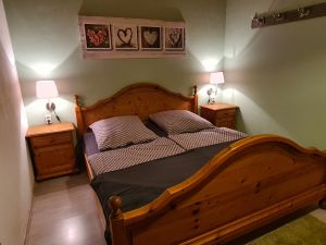 Schlafzimmer mit Doppelbett, zweitürigem Schrank, zwei Nachttischen und Garderobe. Zum Schlafzimmer gehört eine separate Toilette mit Waschbecken. - Bild 15: Urlaub im gemütlichen Ferienhaus Waldhäuschen Zandt- Bayerischer Wald