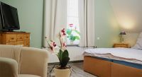 Schlafzimmer 2 im OG Hier finden Sie ein weiteres Doppelbett mit Nachttischschränkchen und -lampen. Ein Kleiderschrank und eine Kommode bieten Stauraum für Ihre persönlichen Sachen. Auch an eine kleine Sitzecke mit 2 Sesseln, Kinderstuhl, Tischchen und Flachbild-TV ist gedacht.
Der Raum ist mit Laminat und Teppichen ausgelegt, das Fenster verfügt über Verdunklungsvorhänge. - Bild 9: Ferienhaus Zur Eiche, Born am Darß, Fischland-Darß-Zingst mit Boddenblick