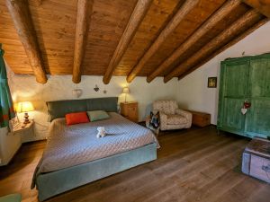 Schlafzimmer mit Doppelbett, TV, Ausgang auf den Balkon im OG - Bild 5: wunderbar ruhig und romantisch gelegenes Ferienhaus in Bezzecca am Ledrosee