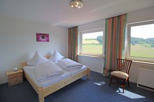 liegt im Erdgeschoss und hat 1 Doppelbett, Nachtschränkchen, Kleiderschrank und wunderschönem Panoramablick. - Bild 1: Ferienwohnung EifelNatur 8 - große Familienwohnung mit Terrasse