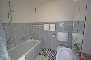 hat eine Badewanne mit Duschvorhang, ein Waschbecken, WC und einen Handtuchwärmer. - Bild 13: Ferienwohnung EifelNatur 8 - große Familienwohnung mit Terrasse