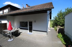 mit großem Tisch, Stühlen, Sonnenschirm und Grill. - Bild 16: Ferienwohnung EifelNatur 8 - große Familienwohnung mit Terrasse