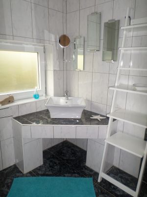 Dieses Duschbad ist nur über das Schlafzimmer zu erreichen. Hier befindet sich ein Waschbecken, ein Spiegel und ein Leiterregal als Ablage. Dieses Zimmer hat einen Heizkörper sowie Fussbodenheizung. - Bild 13: Nordseenahes Ferienhaus in Ostfriesland für Familie und Co