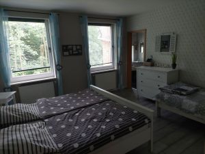 Dieses Schlafzimmer hat ein Zugang zu einem eigenen Duschbad. Es ist ausgestattet mit eienm Doppelbett, Kommode, Kleiderschrank, Nachttischkonsolen. Ein Spiegel sowie ein Fön sind vorhanden. - Bild 11: Nordseenahes Ferienhaus in Ostfriesland für Familie und Co