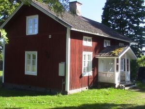Bild 1: Holzhaus wo der Elch wohnt in Ekshärad Värmland, Mittelschweden, Ruderboot