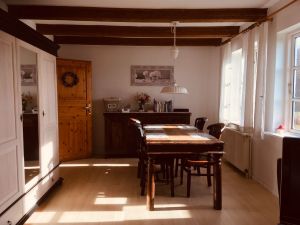 Der ca. 25 m2 große Wohnraum ist in Ess- und Couchecke aufgeteilt. - Bild 6: Urlaub mit Hund in Ostseenähe - komplett eingezäunter Garten