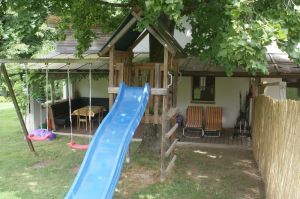 Im Garten befinden sich 2 Schaukel, eine Rutsche und ein Sandkasten mit Spielwaren. Dahinter sehen Sie die große, schattige Terrasse. - Bild 13: Ferienhaus Moser im Ötscherland