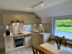 Die Küche ist mit einem Herd, Backofen, Kühlschrank und einer Spülmaschine ausgestattet. Eine Kaffeemaschine und die gängigen Küchenutensilien sind natürlich vorhanden. Es gibt einen Tisch für 4 Personen mit Blick in den Garten. - Bild 7: Ferienhaus Muschel an der Nordsee