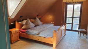 Schlafzimmer 1 DG mit Doppelbett und Zugang zur Dachterrasse mit Strandkorb. - Bild 10: ReetdachFerienhaus Strandperle in St. Peter-Ording