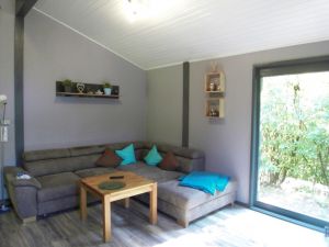 Wohnzimmer mit großer Eckcouch - Bild 10: Ferienhaus Mau & Wau - Waldhessen