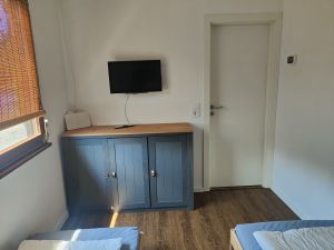 Das Schlafzimmer 2 verfügt über zwei Einzelbetten (80x200 cm), einem Fernseher, einer Kommode und einer Infrarotheizung. - Bild 18: Haus mit Zaun an beliebten Wanderrouten mit Blick in den Sternenhimmel