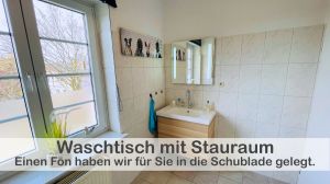 In unserem Badezimmer erwartet Sie ein Waschtisch mit großem Unterschrank, der ausreichend Platz für Ihre persönlichen Pflegeprodukte bietet. Hier finden Sie auch einen Fön, mit dem Sie Ihre Haare bequem trocknen und stylen können. - Bild 25: Ferienwohnung im Gutshaus, Entschleunigung pur für erholsame Tage