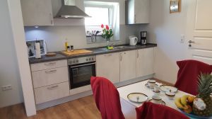 Tisch mit 4 Stühlen und komplett eingerichtete Einbauküche - Bild 3: Ferienwohnung Föhr in der schönen Schleiregion