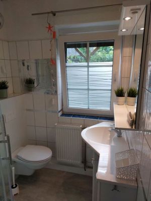 Das geflieste Bad besteht aus einem WC, Dusche und einem Handwaschbecken mit großem Spiegel. - Bild 1: Ferienhaus mit gemütlichem Wintergarten