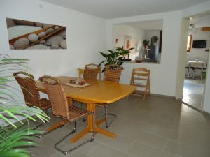 Der offene Koch-, Ess- und Wohnbereich ist mit einer Einbauküche, Tisch
und Stühlen (auch Kinderstuhl) ausgestattet. In der Küche stehen alle
notwendigen Geräten, wie Kühlschrank, Geschirrspülmaschine, Toaster
Backofen mit Cerankochfeld, Mikrowelle, Kaffeemaschine, Wasserkocher,
Geschirr, Töpfen/Pfannen etc. zur Verfügung.

Durch die offene Gestaltung der Räume kann so in der kühlen Jahreszeit
der Ofen die gesamte Wohnung gemütlich warm halten.
Im Sommer ist es angenehm kühl. - Bild 9: Ferienwohnung Haus Baier**** mit Terrasse, in 20 Minuten am Bodensee